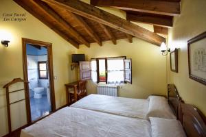 Un dormitorio con una cama grande y un baño. en Casa Rural Los campos, en Corao