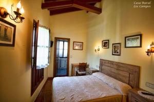 a bedroom with a bed and a table and a window at Casa Rural Los campos in Corao +33 photos