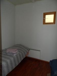 a small room with a bed and a window at Walhalla apartment in Forssa