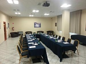 a conference room with long tables and chairs at Albergo Della Roccia in Varano deʼ Melegari