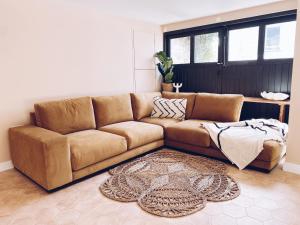 a brown leather couch in a living room at Luxury bolthole in central St.Agnes with parking. in St. Agnes