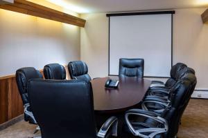 a conference room with a table and black chairs at Prestige Riverside Lodge Quesnel in Quesnel