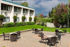a patio with tables and chairs and a building at Prestige Riverside Lodge Quesnel in Quesnel