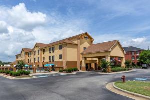 a large hotel with a parking lot and a fire hydrant at Comfort Inn Garner Clayton I-40 in Garner