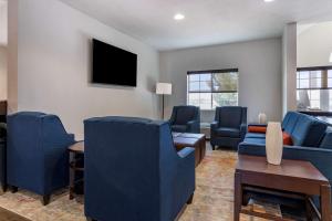 een woonkamer met blauwe stoelen en een tv bij Comfort Inn & Suites in Aztec