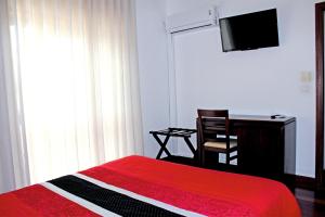 a bedroom with a bed and a desk and a television at Hotel Vale Do Côa in Vila Nova de Foz Coa