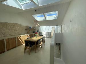 a dining room with a table and some skylights at Chambre d'hôtes Hôte des Portes Île de Ré in Les Portes +20 photos