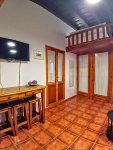 een woonkamer met een houten tafel en een televisie bij La Puerta Verde de las Setas de Sevilla in Sevilla