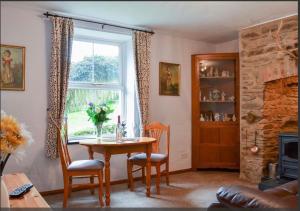 ein Esszimmer mit einem Tisch und einem Fenster in der Unterkunft The Annex Rose Cottage in Lynton