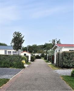 a driveway leading to houses in a neighborhood at Mooi Chalet voor een Top Vakantie aan Zee in Biggekerke