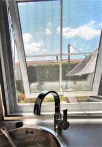 a sink in front of a window with a view of an airplane at Mooi Chalet voor een Top Vakantie aan Zee in Biggekerke