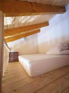 ein weißes Bett in einem Zimmer mit Holzdecke in der Unterkunft Maison de 3 chambres avec balcon amenage et wifi a Courchevel a 1 km des pistes in Courchevel