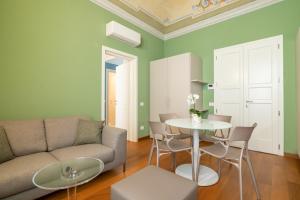 sala de estar con sofá, mesa y sillas en La Suite del Borghetto, en Pisa