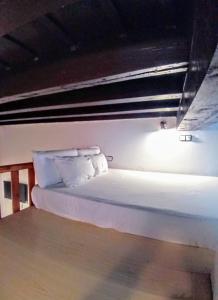 een bed met witte lakens en kussens in een kamer bij La Puerta Verde de las Setas de Sevilla in Sevilla +9 foto's