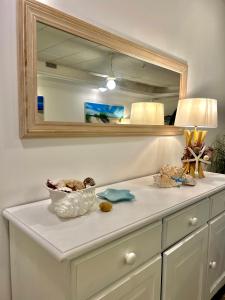 a white sink sitting under a mirror in a bathroom at Hotel Cala Di Seta in Calasetta