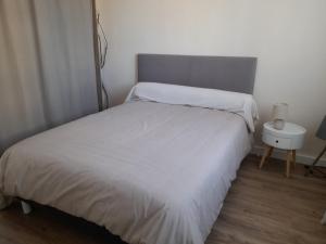 a bedroom with a white bed and a night stand at Appartement Arcachon, 3 pièces, 4 personnes - FR-1-319-458 in Arcachon