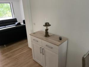 a small white cabinet in a room with a couch at FeWo Wald Idyllika in Willingen +51 photos