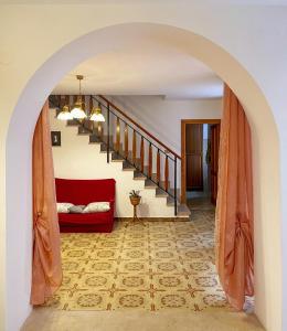 un arco que conduce a una sala de estar con sofá rojo en Elle Shelter, en Scanzano