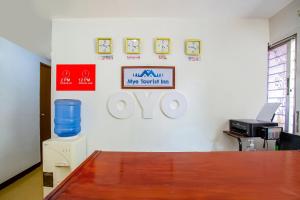 馬尼拉的住宿－OYO 808 Mye Tourist Inn，墙上有桌子和标志的办公室