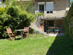 een patio met stoelen en een tafel in de tuin bij Gîte de la tour de Paradis in Poligny