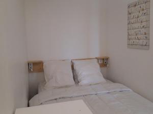 a small bedroom with a bed with white sheets and pillows at Appartement Les Arcs 1800, 3 pièces, 8 personnes - FR-1-346-312 in Arc 1800