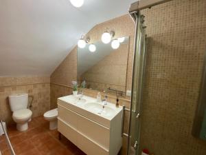 ein Badezimmer mit einem Waschbecken, einem WC und einem Spiegel in der Unterkunft CASA DEL PEZ Vivienda a pie de calle en Agua Amarga a 250 metros de la playa in Agua Amarga