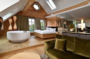 a bathroom with a large tub and a bedroom at Fleesensee Resort & Spa in Göhren-Lebbin