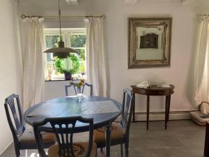 a dining room with a table and chairs and a mirror at Heddahgaarden in Bredal