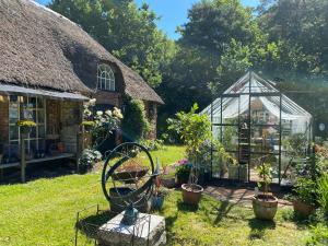 une serre et une maison avec des plantes en pot dans la cour dans l'établissement Heddahgaarden, à Bredal