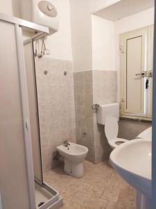 a white bathroom with a toilet and a sink at Casa Cindy in Lamezia Terme