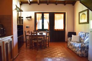 a living room with a table and chairs and a couch at Casale Santa Croce in Pastena