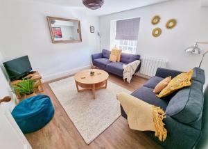 a living room with a blue couch and a table at Eldon Row - Stylish Character Apartments - Central Location 1 & 2 bed available in Dolgellau