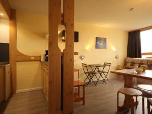 eine Küche und ein Wohnzimmer mit einem Tisch und Stühlen in der Unterkunft Appartement Les Arcs 1800, 2 pièces, 5 personnes - FR-1-346-419 in Arc 1800