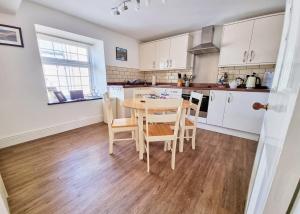 a kitchen with a table and chairs in a room at Eldon Row - Stylish Character Apartments - Central Location 1 & 2 bed available in Dolgellau