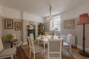 uma sala de jantar com uma mesa branca e cadeiras em Merchants Town House - Catherine Hill em Frome