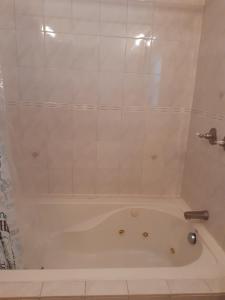 uma banheira branca na casa de banho com um chuveiro em AIRBAB Moon Gate East em Mount Pleasant