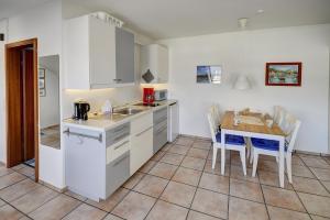 a kitchen and dining room with a table and chairs at fewo1846 Strandresidenz Wassersleben - Kleine Meerjungfrau - komfortables Studioapartment im Dachgeschoss in Harrislee +8 photos