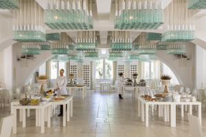 a restaurant with white tables and green glass ceilings at Borgo Egnazia in Savelletri di Fasano