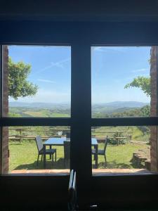 - une vue sur une table et des chaises depuis la fenêtre dans l'établissement Casa di campagna in collina, à Tatti