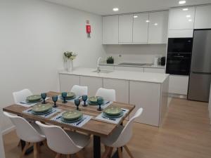 a kitchen with a wooden table and white cabinets at Casa de Ponte in Ponte de Lima