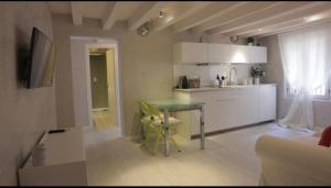 Il comprend un salon avec une table et une cuisine. dans l'établissement MMeSuite Arena di Verona by Maisonme Collection, à Vérone