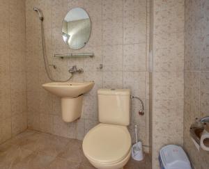 a bathroom with a toilet and a sink and a mirror at Saint George Hotel 2 in Kavarna