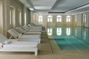 a pool with chaise lounges and a swimming pool at Borgo Egnazia in Savelletri di Fasano