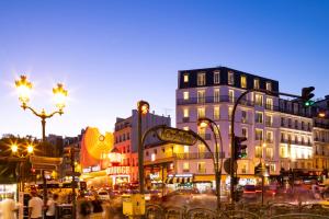 a busy city street at night with traffic lights and buildings at Hôtel Manolita Paris in Paris +32 photos