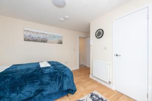a bedroom with a bed and a clock on the wall at Modern Studio Apartments in Castle St in Southampton