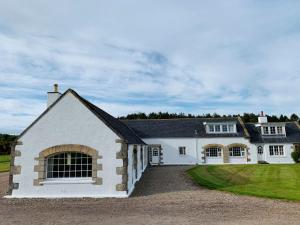a white house with a black roof at Bruntlands Steading in Fochabers