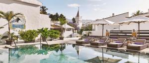 an image of a pool with chairs and a church at Nobu Hotel Marbella in Marbella