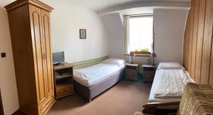 a small room with two beds and a window at Penzión Encián in Vysoke Tatry - Tatranska Lomnica.