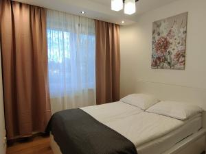 um quarto com uma cama e uma janela com cortinas em Apartament F&J #12 em Toruń