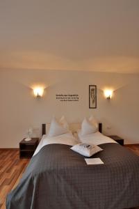 a bedroom with a large bed with two pillows at Hotel am Marktplatz in Gangkofen